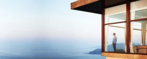 Un homme debout face à l’océan sur un balcon qui surplombe la concha à San Sebastian. A man standing facing the ocean on a balcony overlooking the Concha in San Sebastian